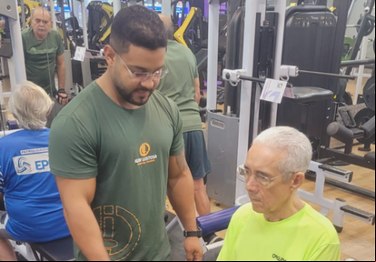 Dr. Poncion Rodrigues fortalece seus músculos com a supervisão de seu personal Igor Lustosa